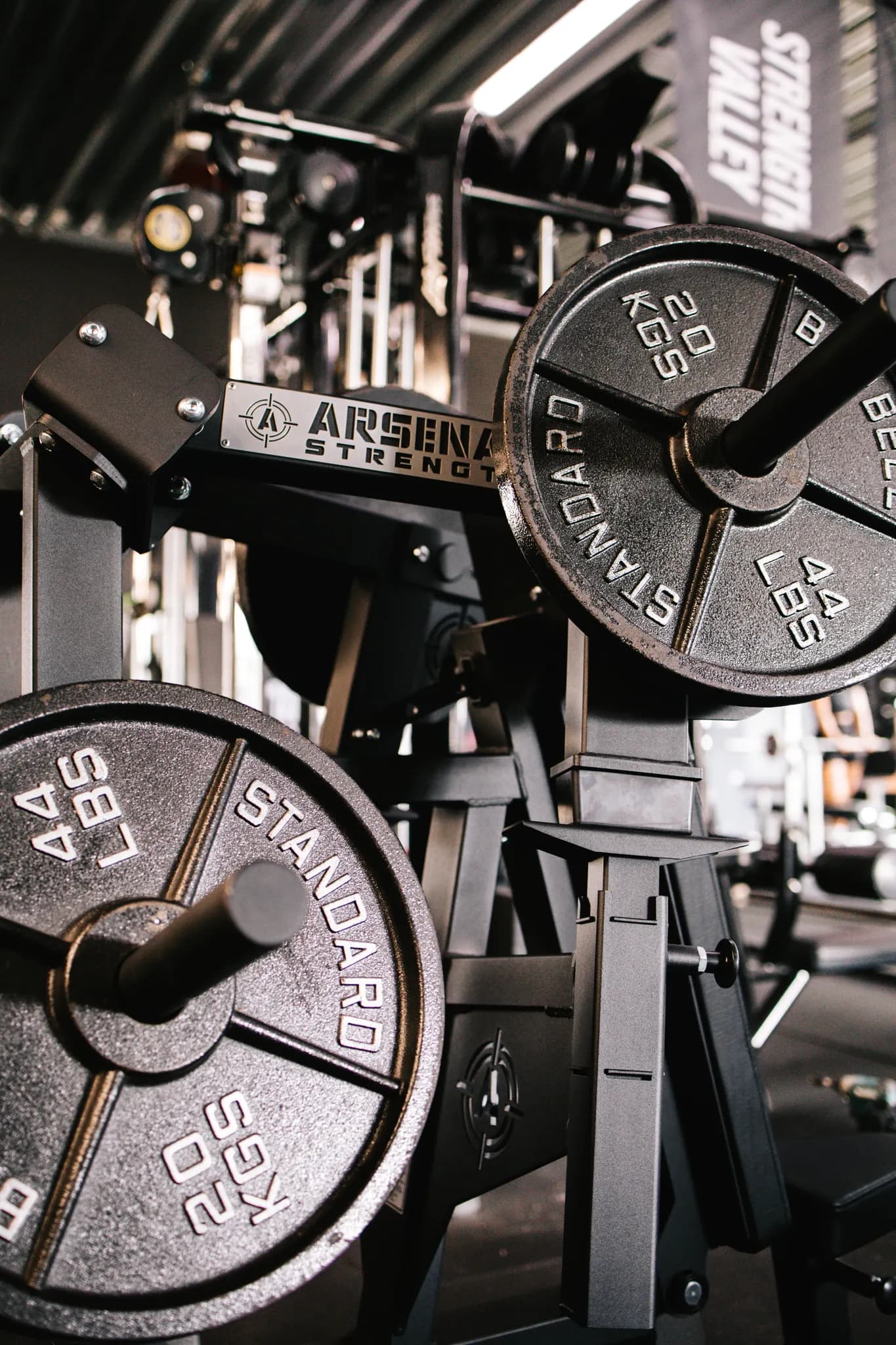 Zwarte Arsenal Strength-schijven van 20 kilo aan een plate-loaded machine